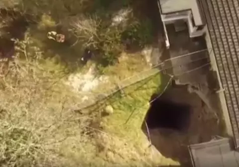 Un crater uriaș a apărut în curtea unei case. Imagini senzaționale cu groapa, filmate cu o dronă / VIDEO