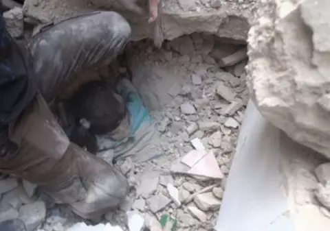 O fetiță a fost scoasă de sub dărâmături în Alep, după ce locuința i-a fost distrusă de un raid. Familia ei a murit în urma bombardamentelor | Imagini dramatice