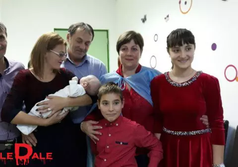 Un bebeluș aruncat de mama sa într-un pârâu a fost botezat. Nași i-au fost asistenta și polițistul care l-au salvat