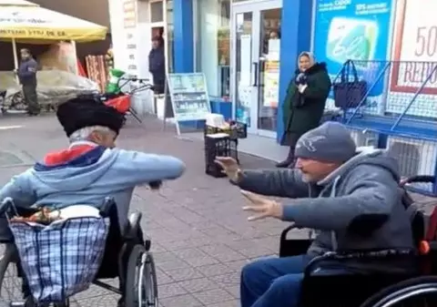 Scandal între doi cerșetori în scaune cu rotile în Piatra Neamț. Oamenii s-au bătut, iar martorii i-au filmat pentru amuzament | VIDEO