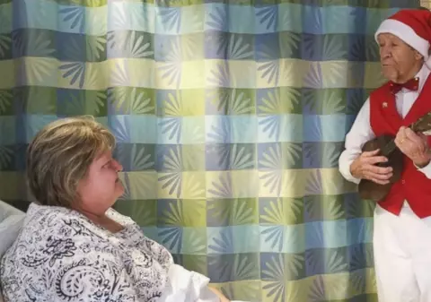 O tradiție de 15 ani: un bătrân de 89 de ani le cântă pacienților unui spital, de Crăciun