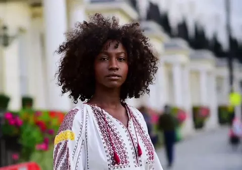 VIDEO|Povestea fetei de culoare care a purtat ie pe străzile din Londra. Lilly e bancher și iubește costumul popular românesc!