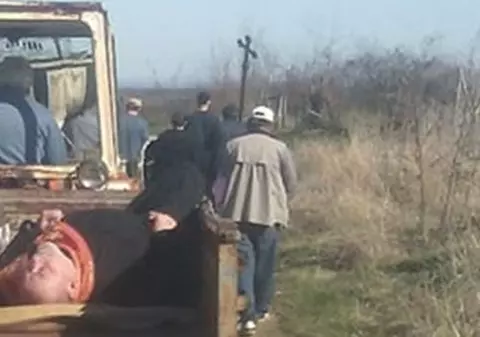 FOTO | Un preot în stare de ebrietate a fost pus de săteni lângă un sicriu și cărat într-o remorcă până la cimitir