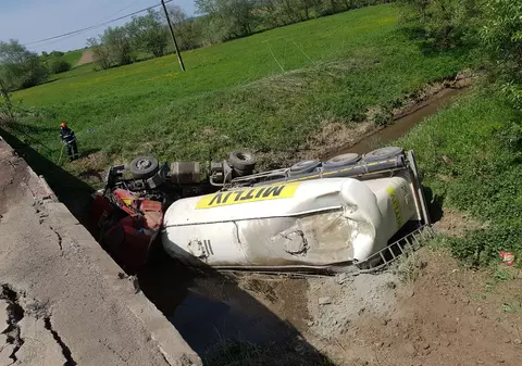 Un TIR încărcat cu ciment s-a răsturnat într-un pârâu, în judeţul Braşov. Există scurgeri de combustibil, iar şoferul a fost rănit/FOTO