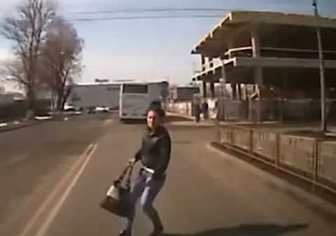 VIDEO | O femeie s-a aruncat în fața unei mașini pentru face rost de bani. Momentul șocant a fost filmat
