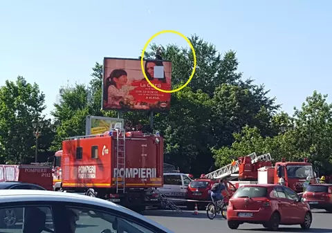 Protest în centrul Capitalei: un bărbat amenință că se aruncă de pe un panou publicitar