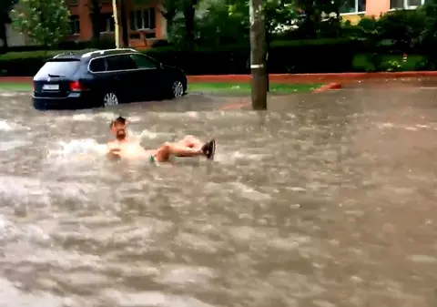 Cu salteaua în mijlocul inundației din București. La scăldat pe bulevard. | VIDEO