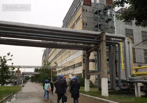 Doi drumari mută cu lopata apa strânsă pe marginea drumului pe un șantier din Timișoara