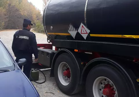 Șoferii de TIR-uri fac asta de ani buni. Cum l-au prins jandarmii pe un bărbat, cu furtunul în gură |FOTO