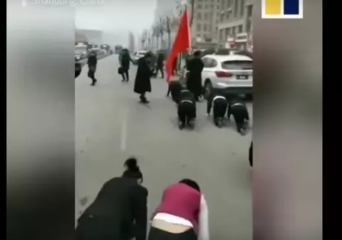 VIDEO | Angajații unei companii au fost forțați să se târască în genunchi pe străzi, fiindcă n-au îndeplinit norma de profit