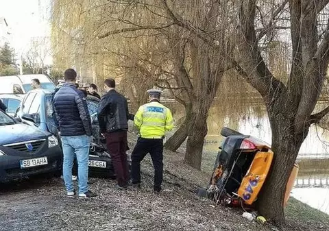 Un taxi era să ajungă în apele Cibinului. S-a răsturnat, dar s-a proptit de un pom