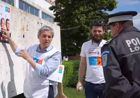 VIDEO | Dacian Cioloș a fost luat la întrebări de un polițist local din Teleorman în timp ce lipea un afiș electoral cu alianța USR-Plus