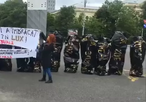Protest în saci de cadavre la Guvern și în fața Ministerului Finanțelor. Artiștii s-au culcat pe trepte în sacii desenați cu simbolurile unei case de modă de lux / VIDEO