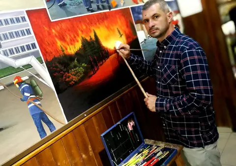 Stinge incendiile, apoi le „aprinde” pe pânză. Un pompier recreează în fața șevaletului clipele dramatice din timpul luptei cu focul