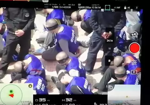 Sute de oameni cu cătușe și legați la ochi, filmați cu drona în China. Ar fi fost duși în lagăre de concentrare