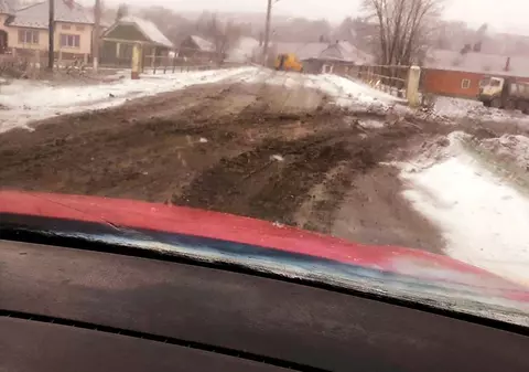 Imagini incredibile surprinse într-un sat din Bistrița. S-a asfaltat un drum în timp ce afară ningea