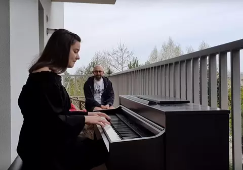 O româncă de 14 ani a cântat la pian, din balcon, pentru medici și asistente