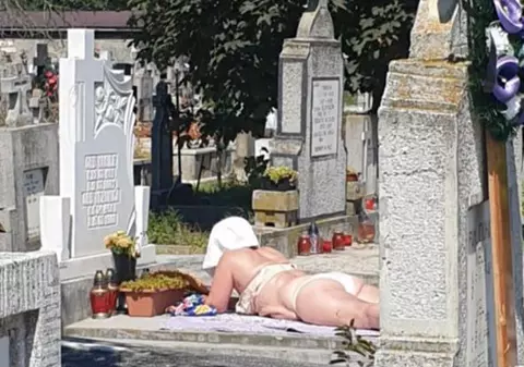 La plajă, într-un cimitir din Alba Iulia. O femeie şi-a întins pătura pe un mormânt