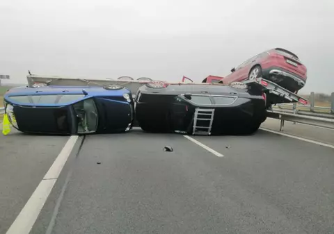O autoutilitară care transporta mai multe mașini de lux s-a răsturnat pe Autostrada Vestului