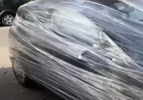 Mașină acoperită cu folie pe o stradă în Suceava, din cauza felului în care a fost parcată