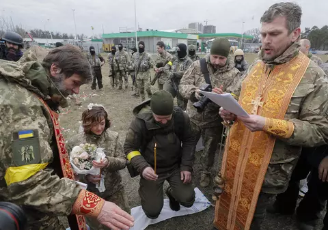 Nuntă pe front. În haine de camuflaj, cu alai înarmat cu flori și puști, doi militari ucraineni s-au căsătorit