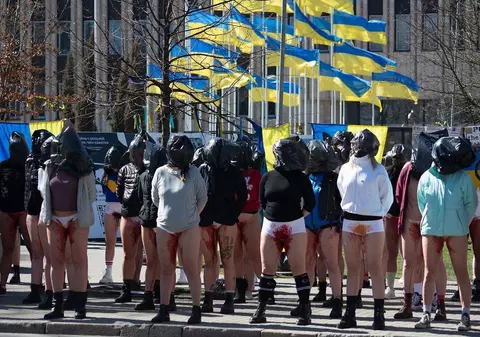 Cu vopsea roșie pe corp, mâinile legate la spate și saci negri pe cap, femeile din Letonia au protestat față de violurile comise de ruși în Ucraina