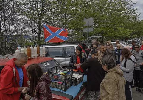 Locuitorii rămași în Mariupol stau la cozi pentru a primi pachete mici cu mâncare. Unii leșină așteptând