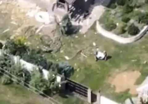 Soldații ruși care fură o mașină de spălat dintr-o casă ucraineană bombardată, filmați cu o dronă - VIDEO