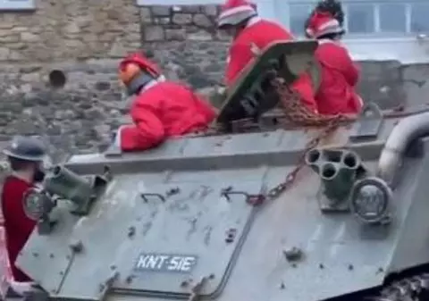 Mai mulți barbați îmbrăcați în Moș Crăciun au creat haos într-un sat din Anglia, după ce s-au blocat cu un tanc pe străduțele înguste