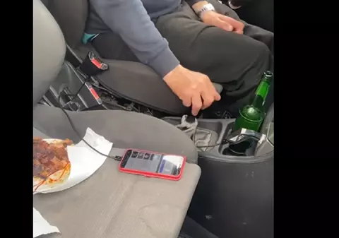 Șofer filmat de o polițistă cu friptura pe bancheta din dreapta și berea lângă schimbător, pe o șosea din Dolj: „Dați muzica mai încet”