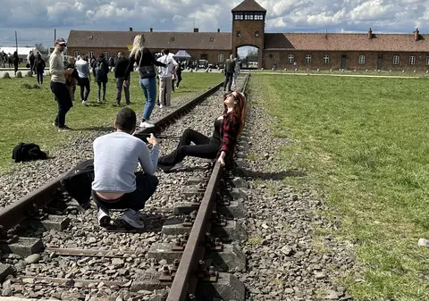 O tânără care pozează lasciv pe șinele de tren de la Auschwitz a stârnit indignare pe internet. „Nu întinați memoria lor”