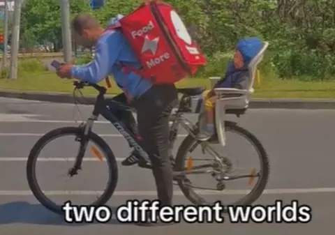 Un livrator pe bicicletă, care merge cu copilul adormit în spate, este căutat de sute de oameni care vor să-l ajute | VIDEO