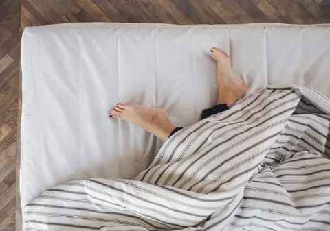 De ce dormim mai bine cu un picior scos de sub pătură