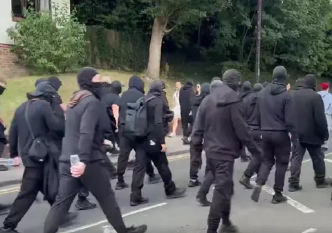 Bărbați mascați cu cagule și îmbrăcați în negru blochează portul Dover din Marea Britanie, în semn de protest față de imigranți