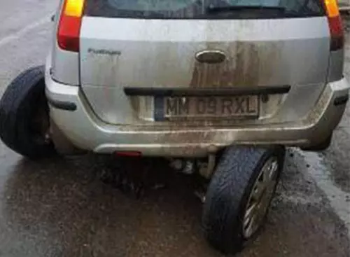 Și-a rupt maşina în două într-o groapă acoperită cu apă