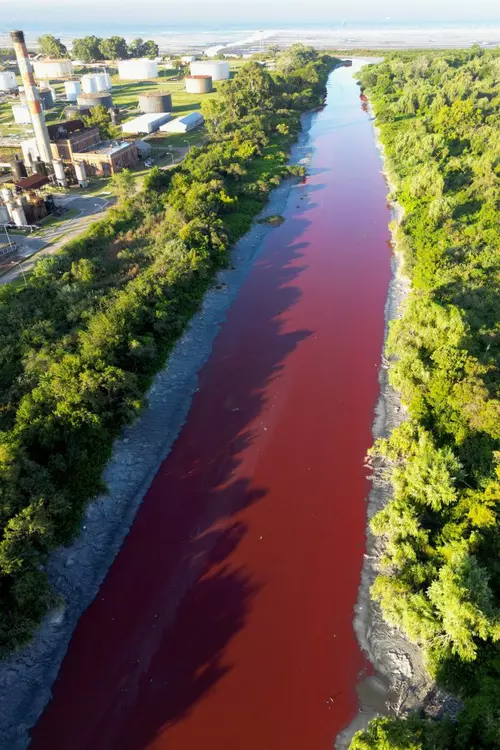 Imagine aeriană cu un râu roșu, în argentina, cu malurile cu vegetație verde