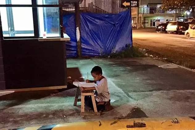 Imagini cutremurătoare! Un copil de 9 ani îşi face temele pe strada, la lumina unui restaurant. Ce s-a întâmplat cu el 