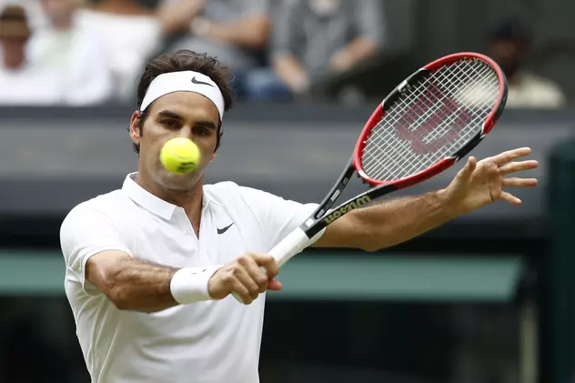 Jucătorul de tenis Roger Federer încearcă să trimită mingea peste fileu în timpul unei partide de la Wimbledon. (FOTO: EPA)