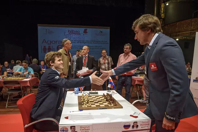 Magnus Carlsen (stânga) îi strânge mâna lui Serghei Kariakin la finalul unei partide de șah. (FOTO: EPA)