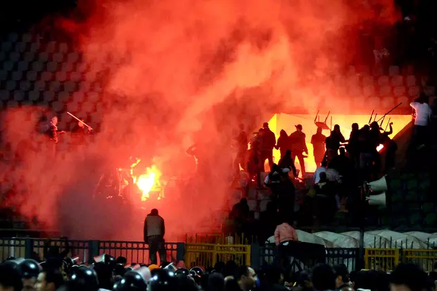 Fani egipteni cu torțe aprinse în timpul incidentelor produse pe 1 februrie 2012, la sfârșitul meciului Al-Masri - Al-Ahli. (FOTO: EPA)