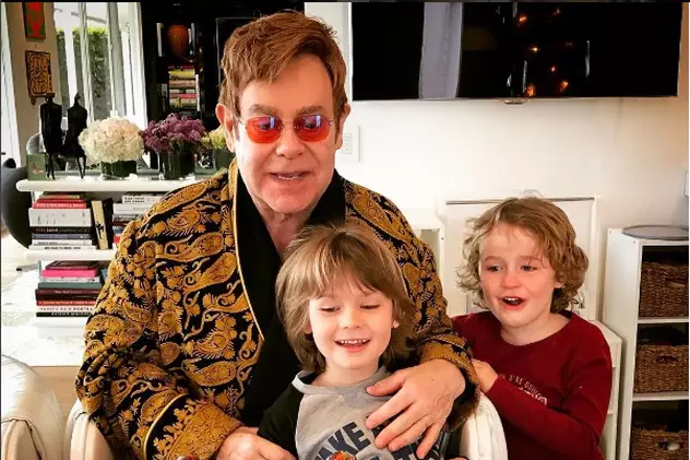 Elton John alături de cei doi copii ai săi și un tort de ciocolată