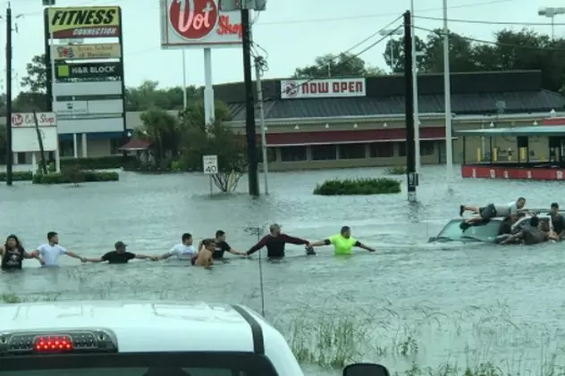 Clipe dramatice în orașul Houston, aflat sub ape. Oamenii au format un lanț uman pentru a salva un om blocat în mașina sa | VIDEO