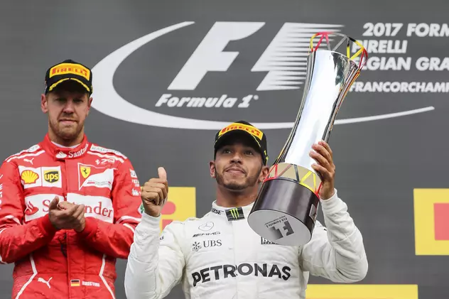 Lewis Hamilton ridică un trofeu deasupra capului, sub privirile lui Sebastian Vettel. (FOTO: EPA)