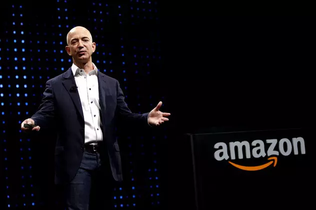 Jeff Bezos e acum de două ori mai bogat decât Mark Zuckerberg. Bezos pe o scenă, cu logo-ul Amazon în spate