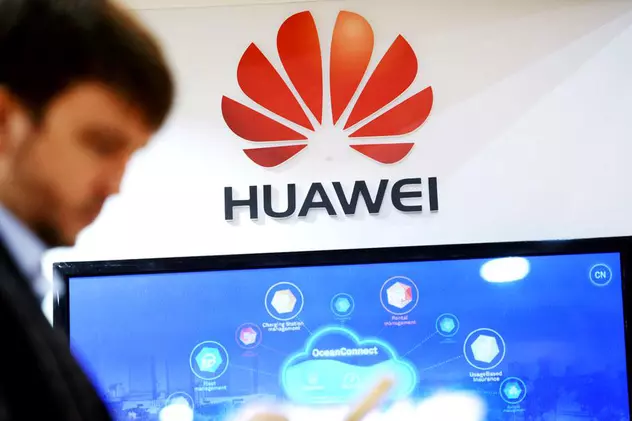 Huawei estimează că o depășească Samsung și o să ajungă în acest cel cel mai mare producător de telefoane. Bărbat cu un smartphone în mână și logo-ul Huawei în spate