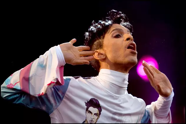 Nimeni nu va fi pus sub acuzare, în cazul morții lui Prince. Prince, în timpul unui concert, cu o bluză albă, cu mânecă lungă, pe care e imprimat chipul său
