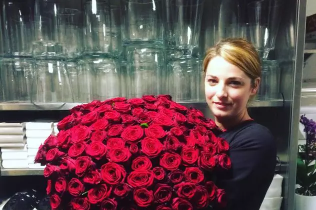 designerul român care decorează camera de hotel a Rihannei. Silvia Coman, cu un buchet imens de trandafiri roșii în brațe