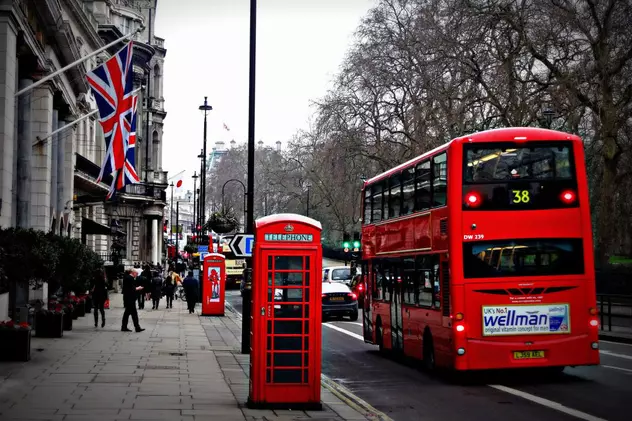 Ce este Universal Credit (Creditul Universal). Autobuz supraetajat și o cabină telefonică, ambele roșii, în Londra