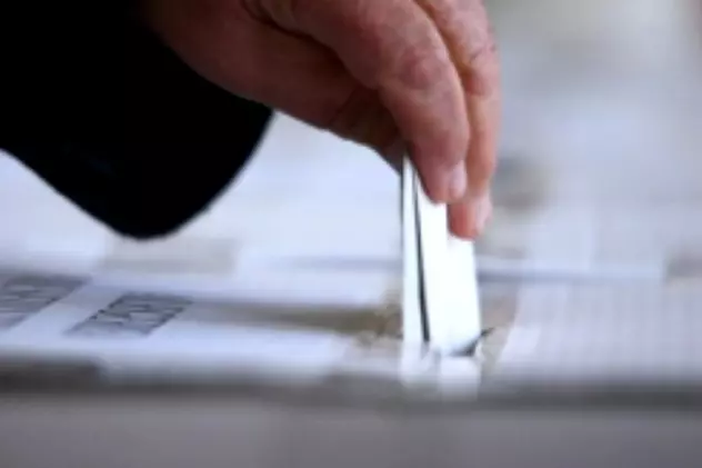 Detalii despre Referendumul din 6 și 7 octombrie. Un votant introduce buletonul de vot în urnă