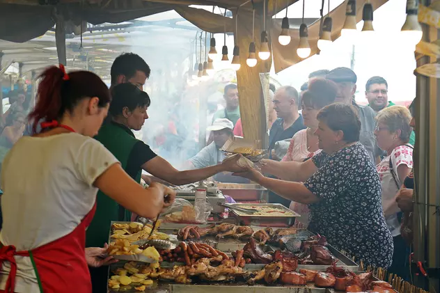 Festivalul Cârnaților de Pleșcoi, anulat din cauza referendumului pentru familie. Oameni care se înghesuie la cârnați, într-un târg din Oltenia